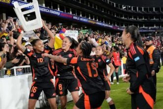 Colombia's Jorelyn Carabali holds a stool up as she celebrates with teammates after they win the penalty shootout