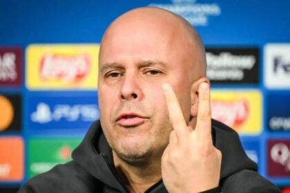 Arne Slot puts two fingers up during a press conference.