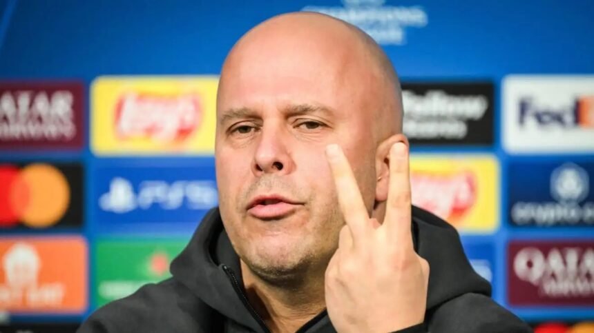 Arne Slot puts two fingers up during a press conference.
