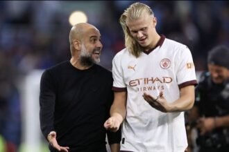 Man City manager Pep Guardiola speaks to Erling Haaland