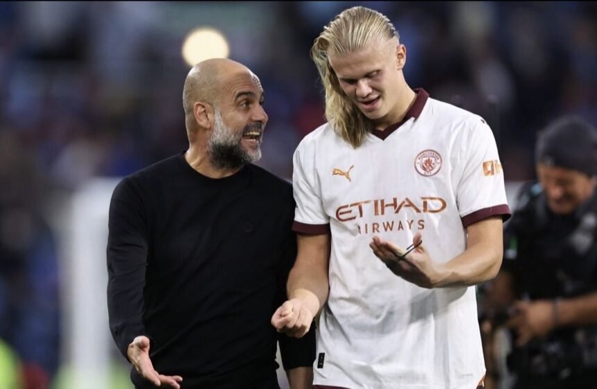Man City manager Pep Guardiola speaks to Erling Haaland
