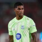 Marcus Rashford with Man Utd and FC Barcelona's badges.