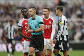 Saka (L) complains to referee Jarred Gillett (middle)