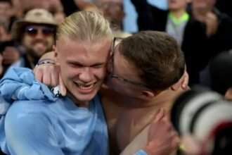 Erling Haaland is kissed by a fan in the stands.