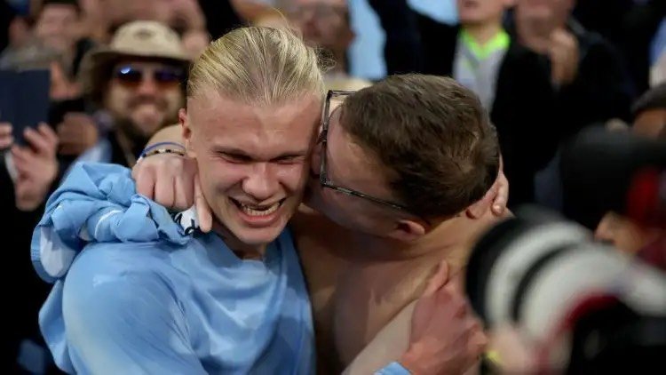 Erling Haaland is kissed by a fan in the stands.