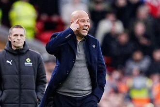 Arne Slot sends a message to his players during a Premier League match.